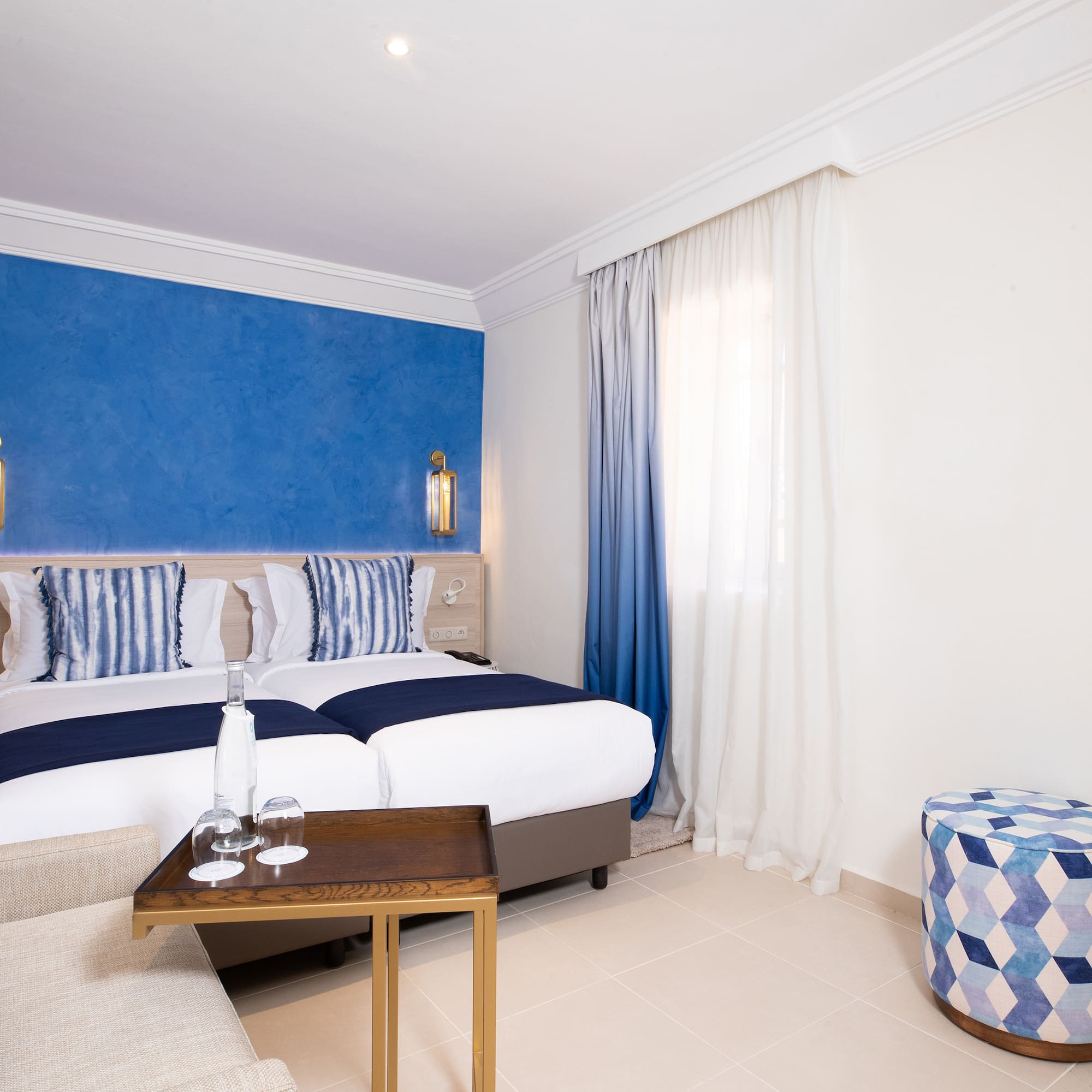 a room with a bed and a stool