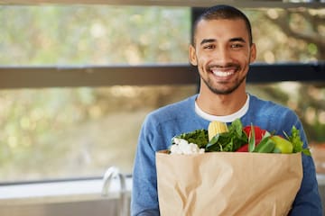 a man holding a bag of vegetables