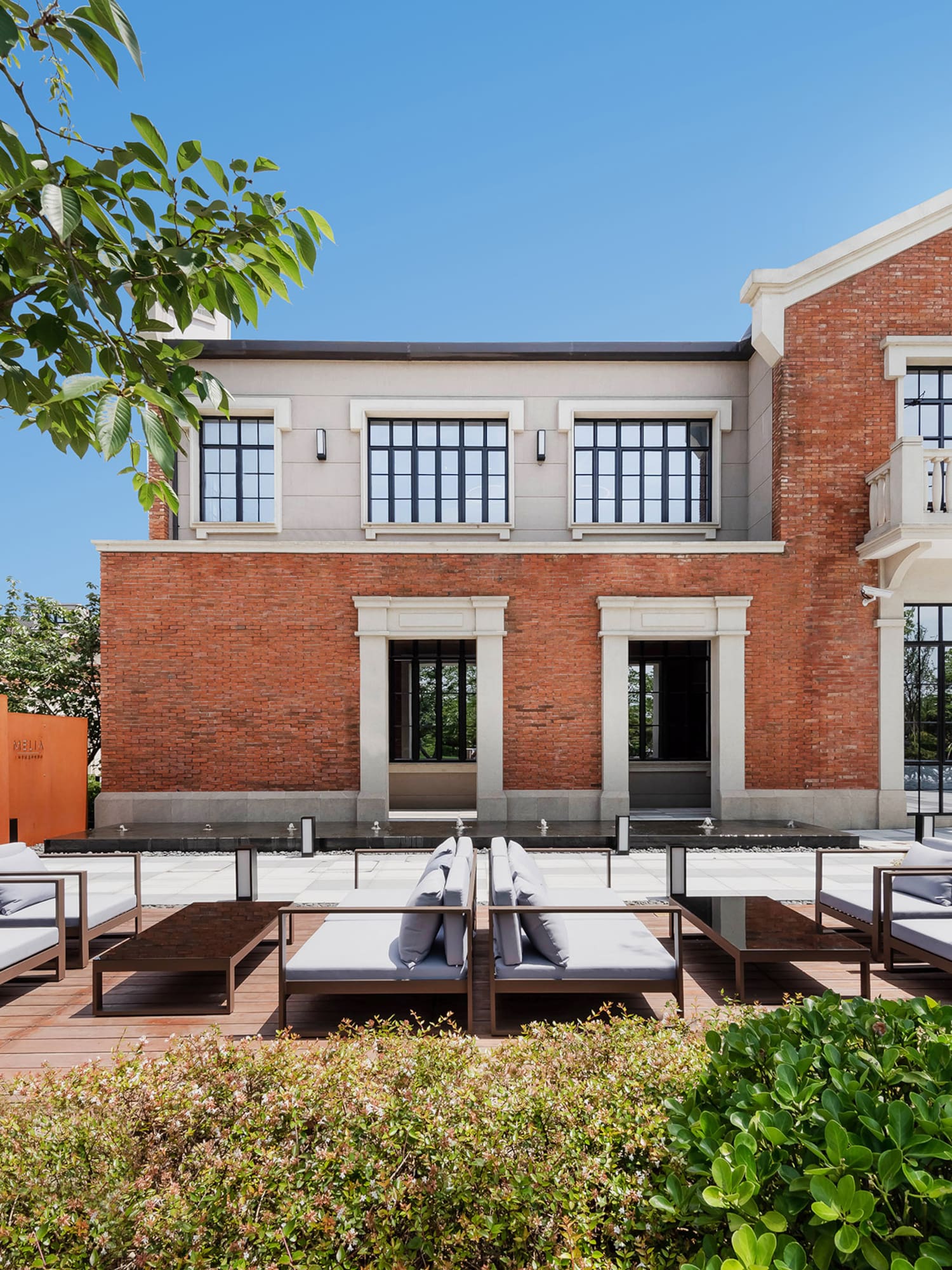 a brick building with a patio area and chairs