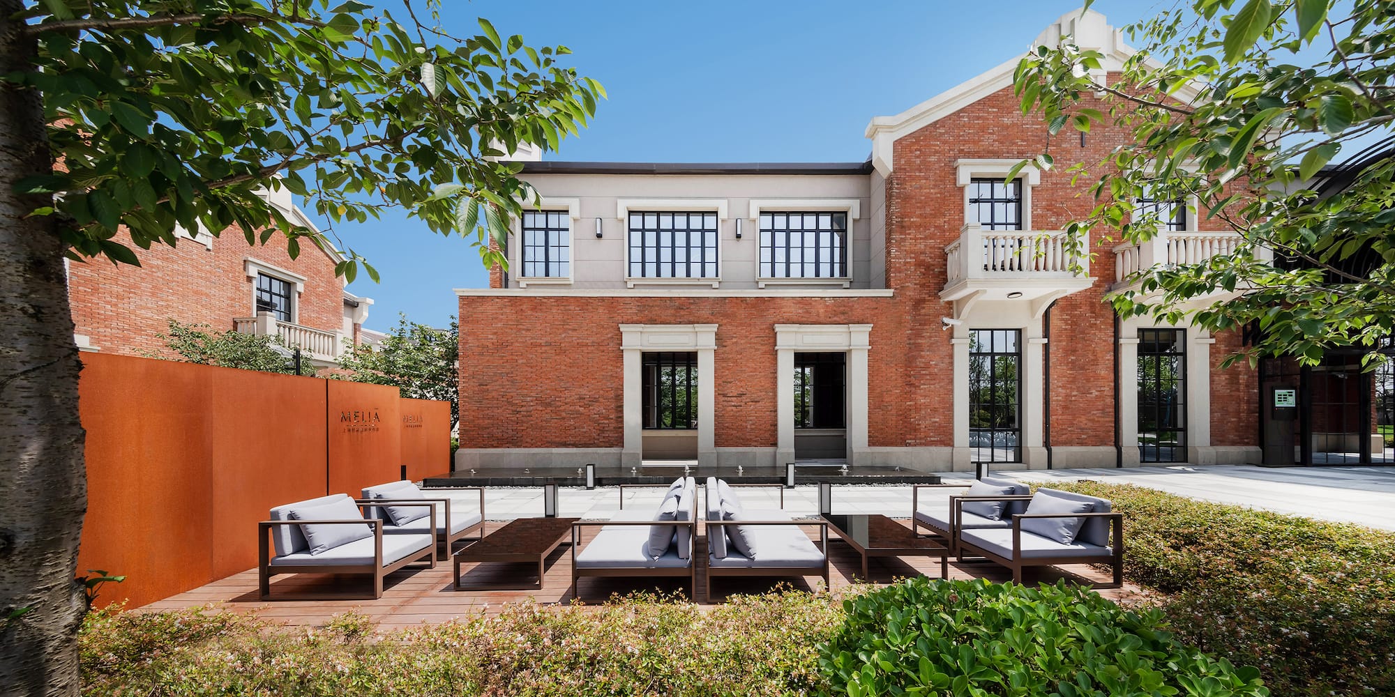 a brick building with a patio area and chairs