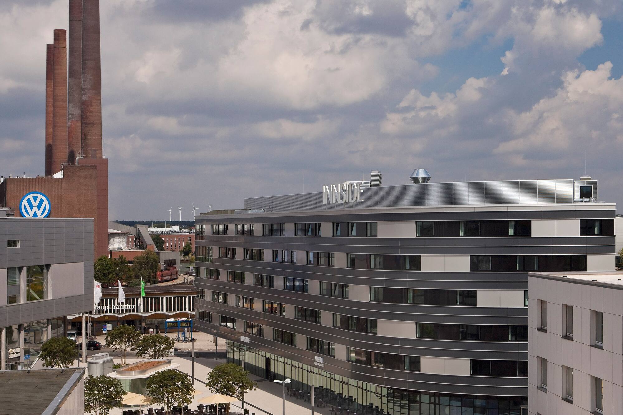 INNSIDE hotel, Volkswagen factory chimneys, and city square in Wolfsburg.