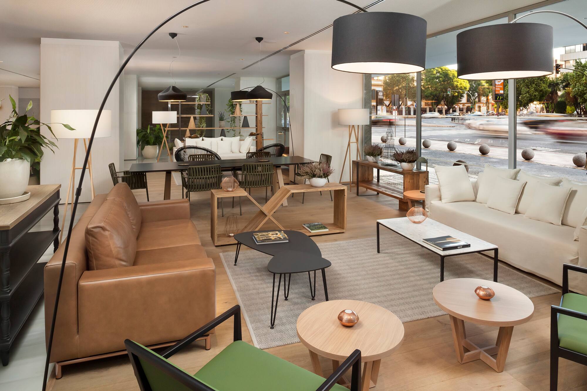Modern lounge, brown leather sofa, white couch, coffee tables, city view.