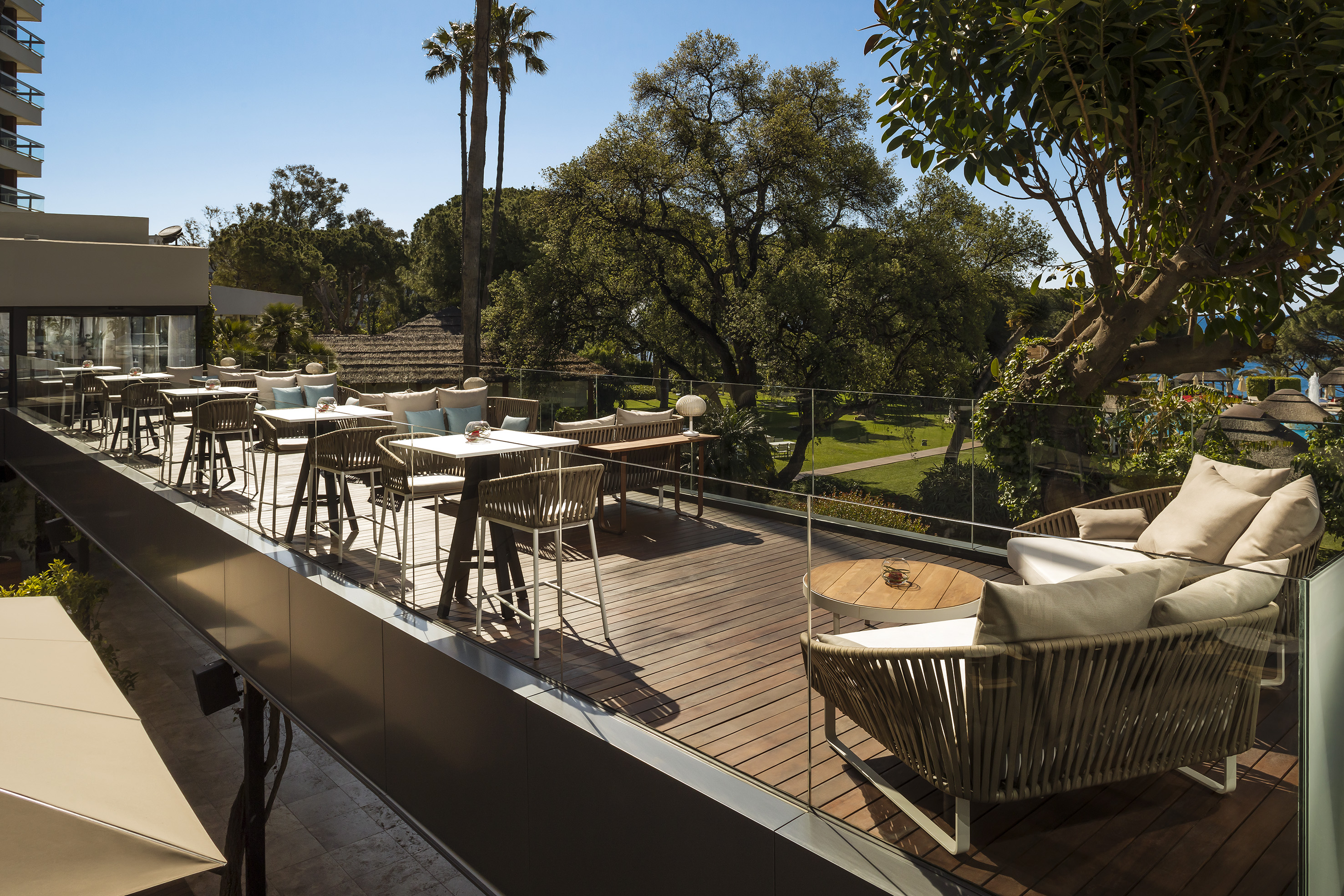 a patio with tables and chairs on a deck