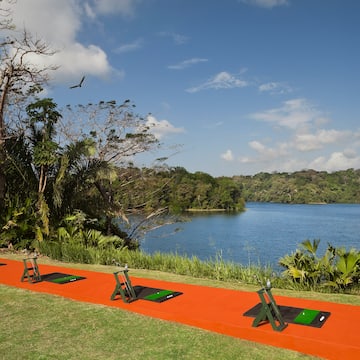 a row of yoga mats on a path next to a body of water