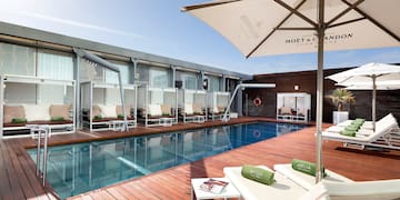 a pool with lounge chairs and umbrellas