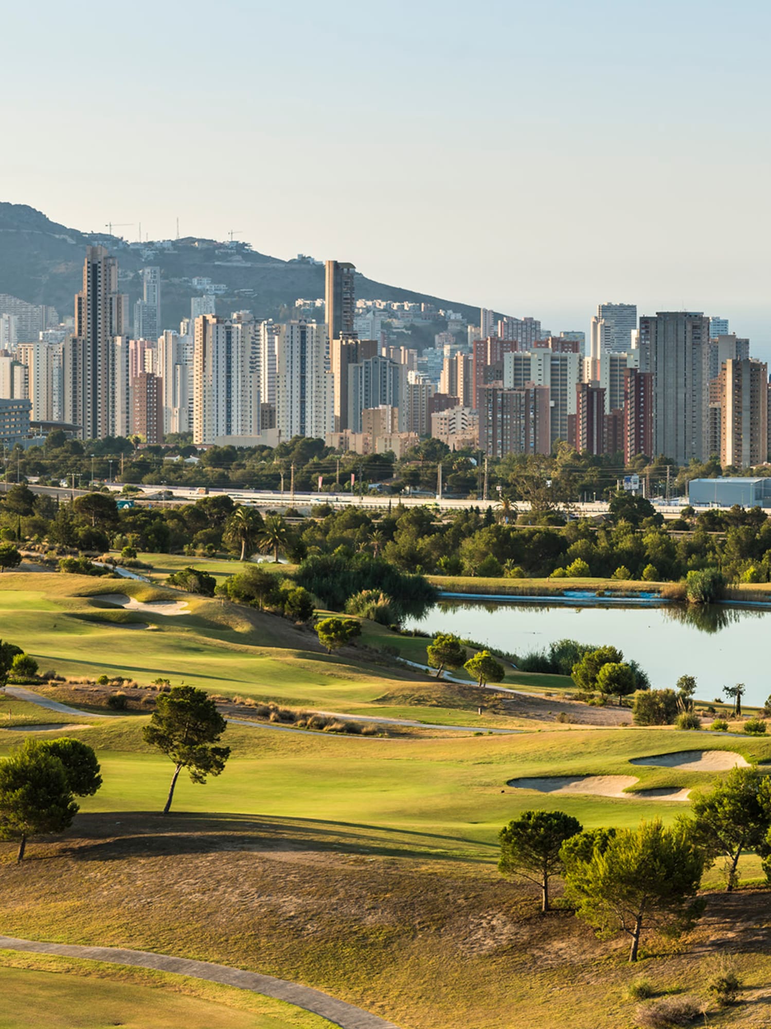 a golf course with a city in the background