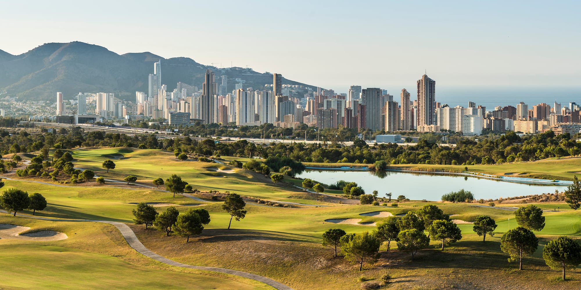 a golf course with a city in the background