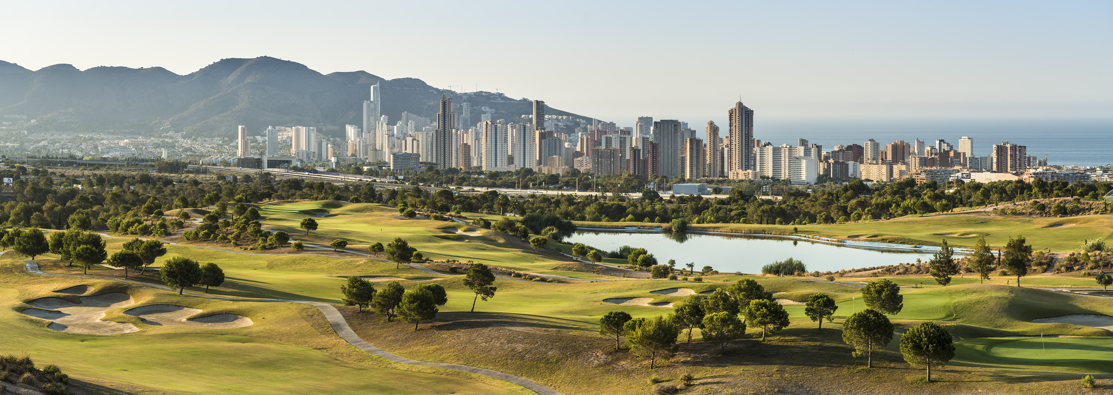 a golf course with a city in the background