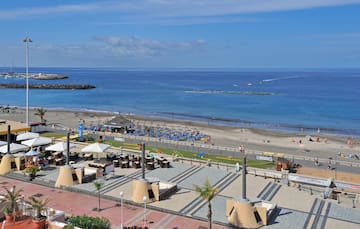 a beach with a lot of people and a body of water