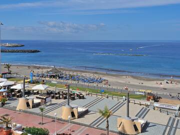a beach with a lot of people and a body of water