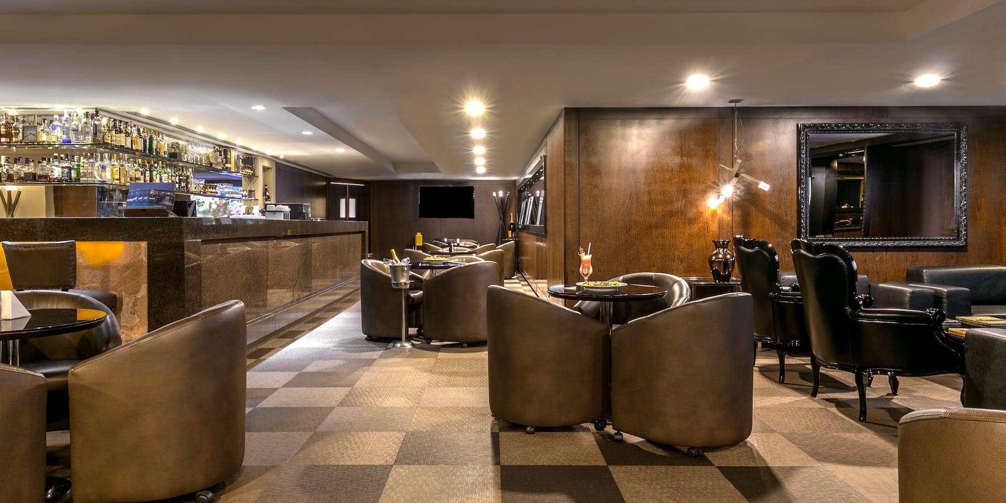 a room with a checkered floor and a bar with tables and chairs