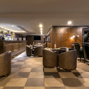 a room with a checkered floor and a bar with tables and chairs