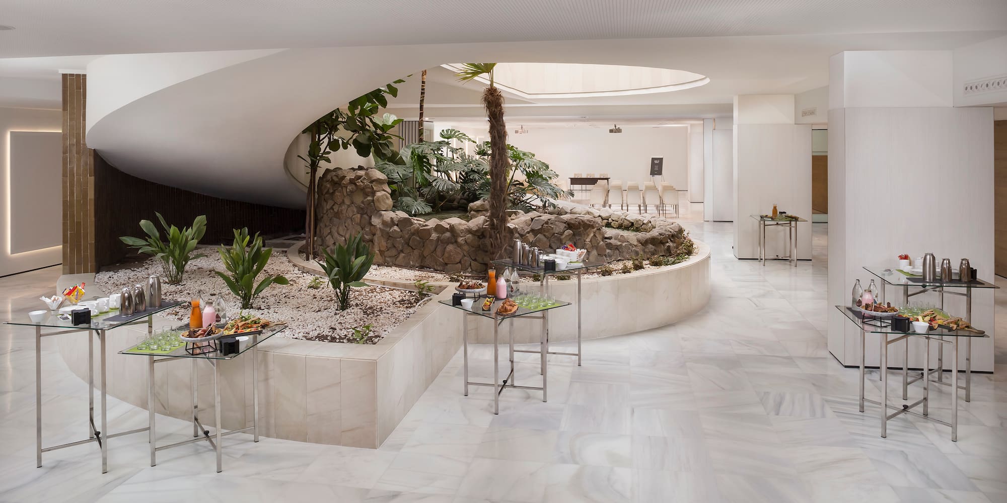 a room with a circular structure with tables and plants