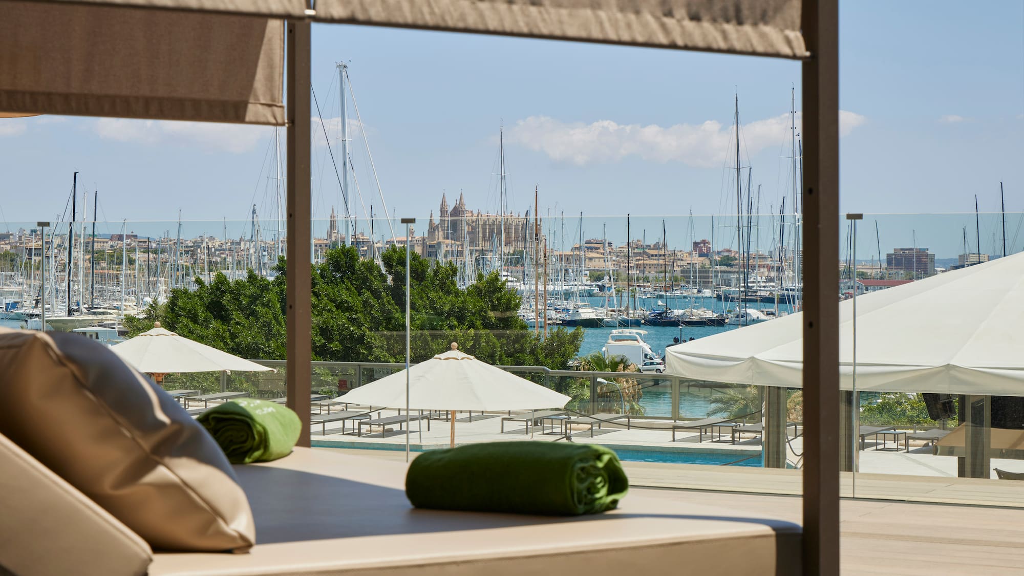 a view of a city from a room with a pool and umbrellas