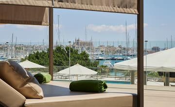 a view of a city from a room with a pool and umbrellas