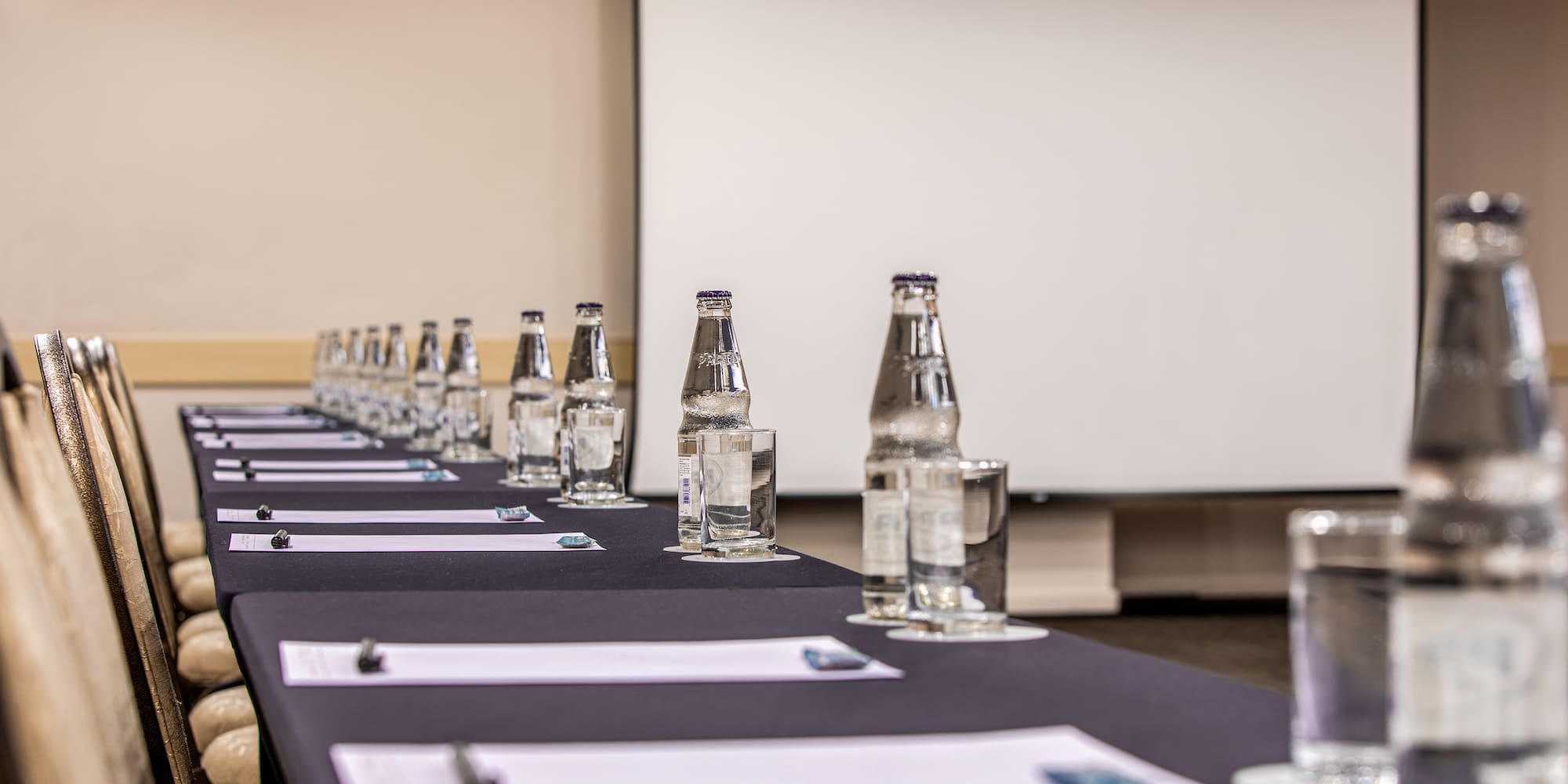 a long table with water bottles and glasses on it