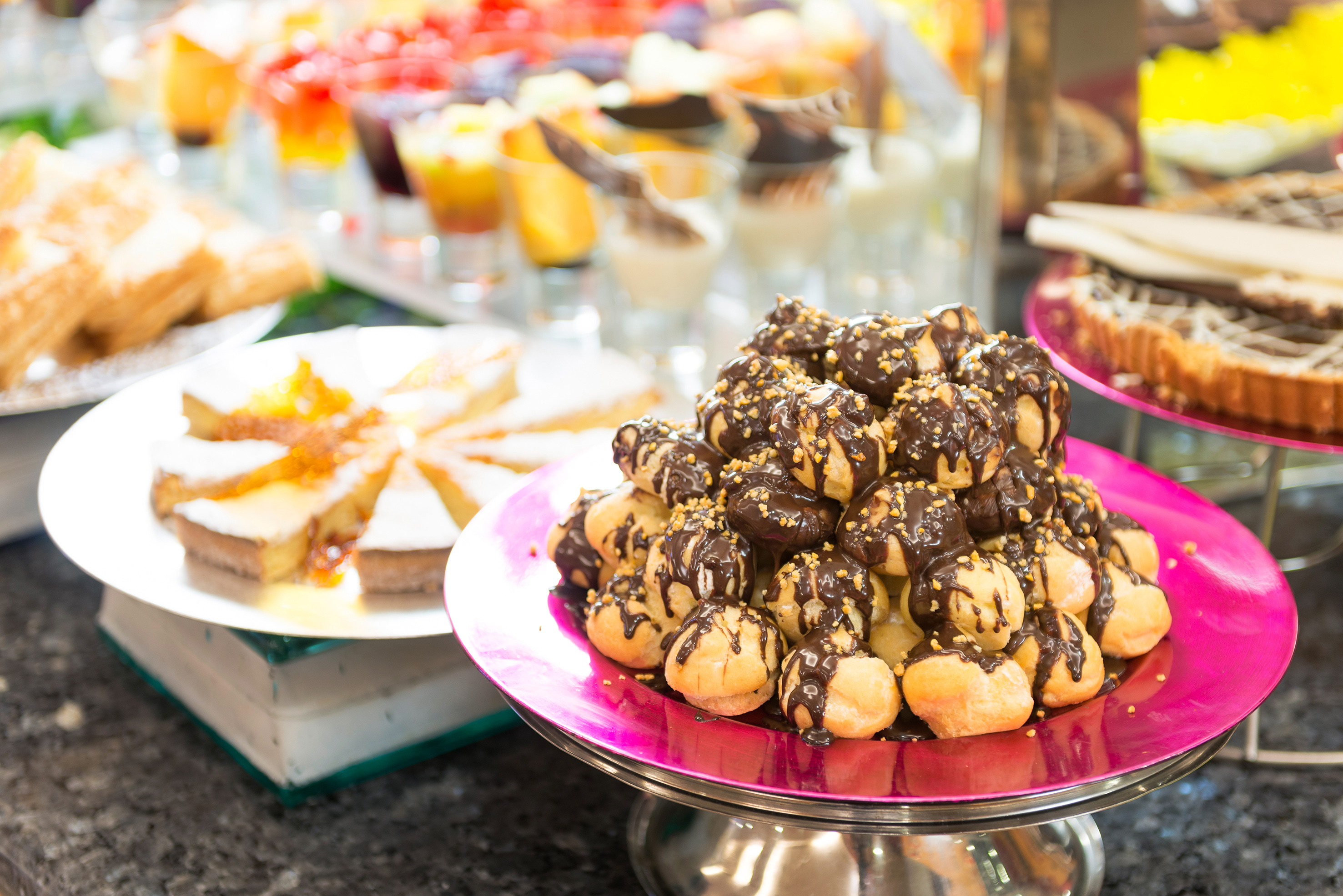 Chocolate profiteroles with nuts at a sweet dessert buffet.