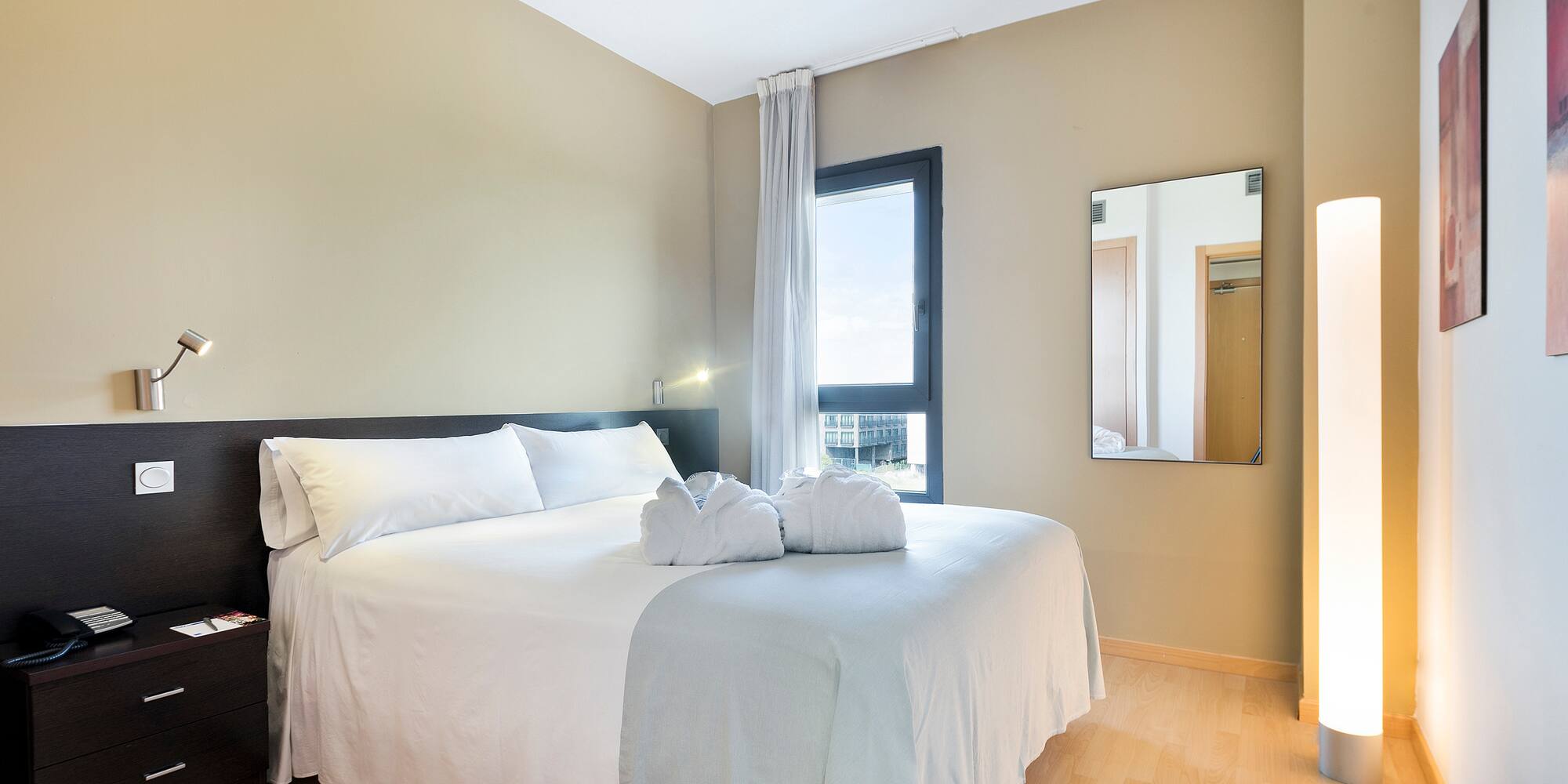 a bed with white sheets and towels on it