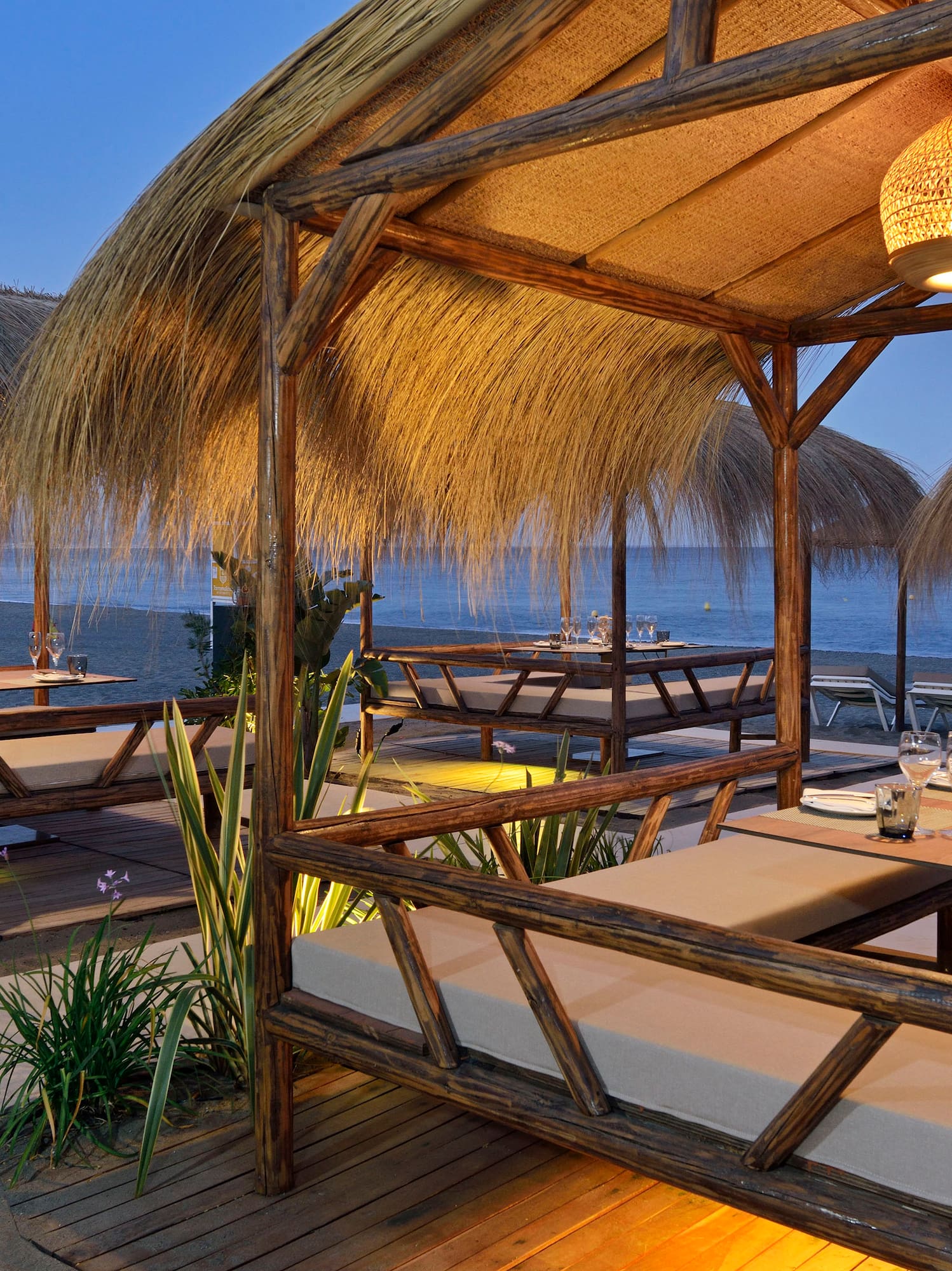 a restaurant with a thatched roof and tables and chairs
