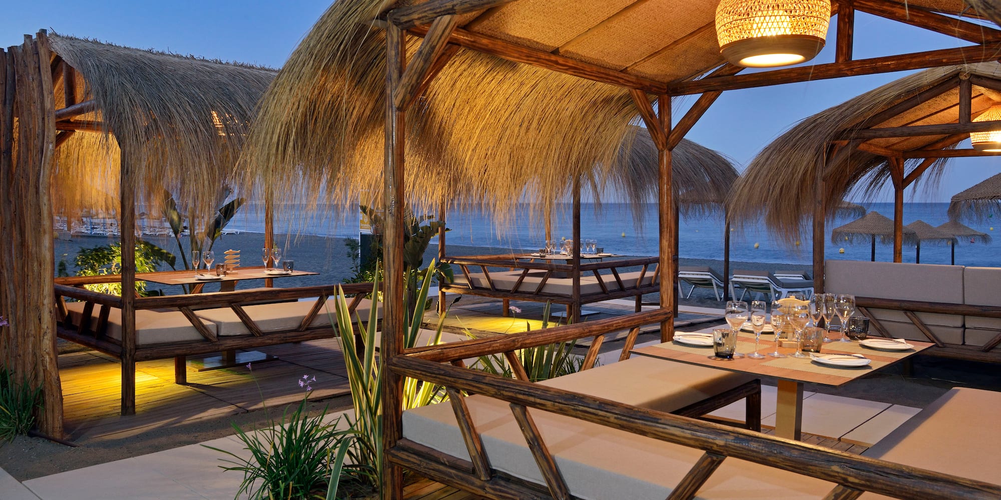 a restaurant with a thatched roof and tables and chairs
