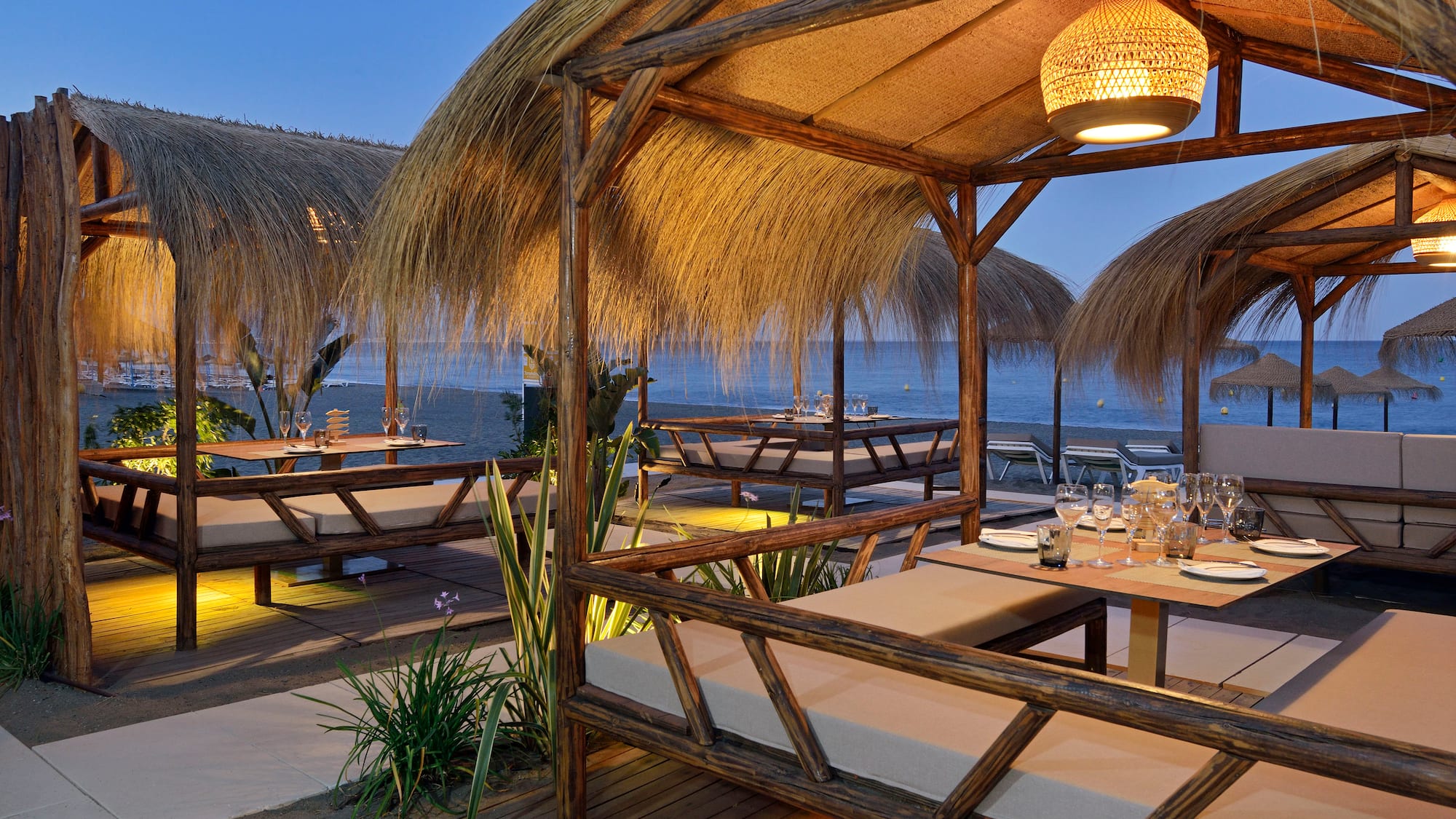 a restaurant with a thatched roof and tables and chairs