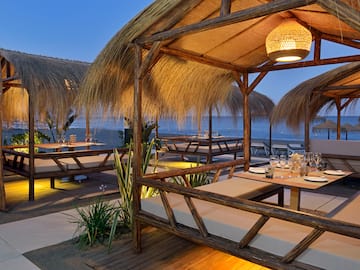 a restaurant with a thatched roof and tables and chairs