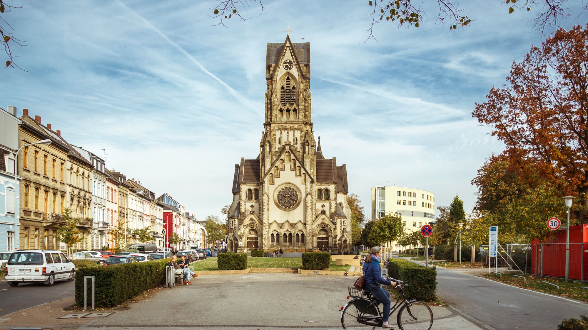 a person riding a bicycle in front of a church