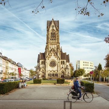 a person riding a bicycle in front of a church