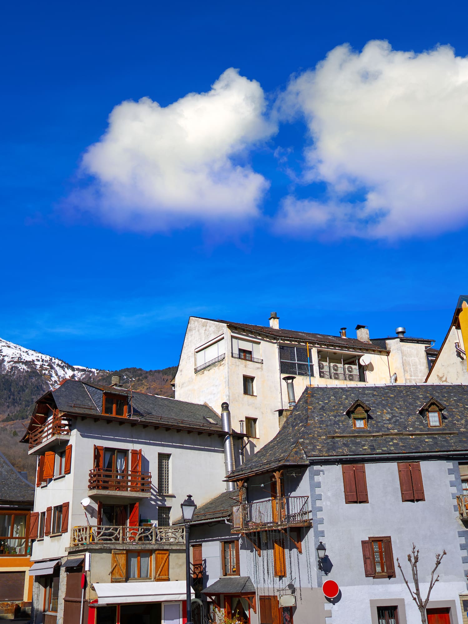 a group of buildings with snow capped mountains in the background