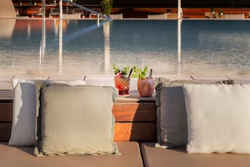 a two pillows on a table next to a pool