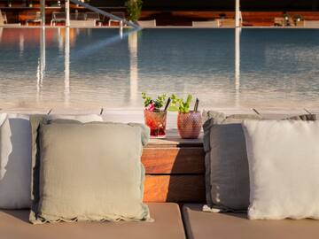 a two pillows on a table next to a pool