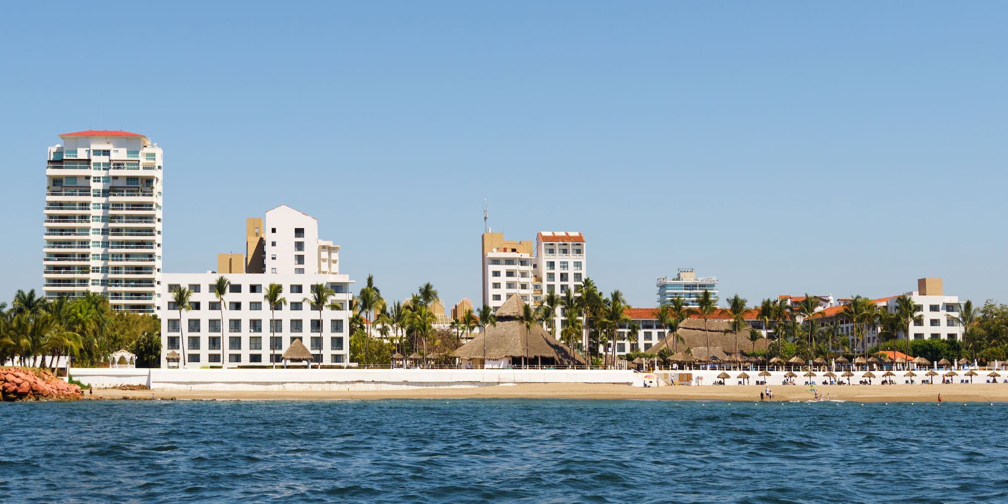 a body of water with buildings and palm trees