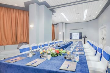 a long table with blue tablecloths and flowers on it