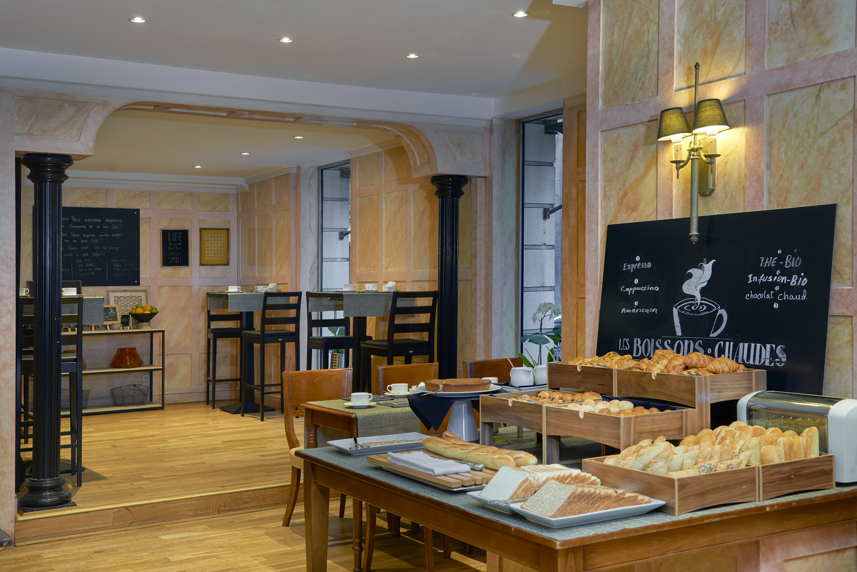 Hotel breakfast buffet: croissants, fresh bread, toaster, and hot drink menu.
