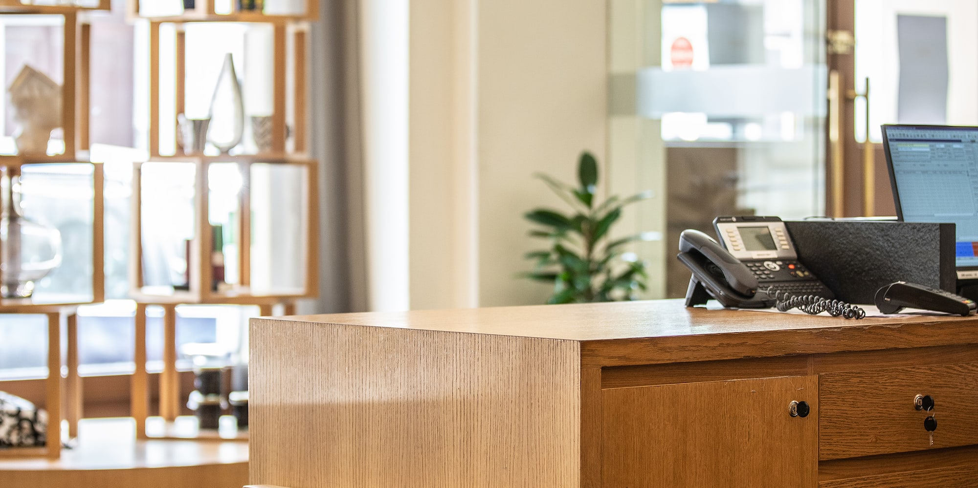 a desk with a telephone and a laptop