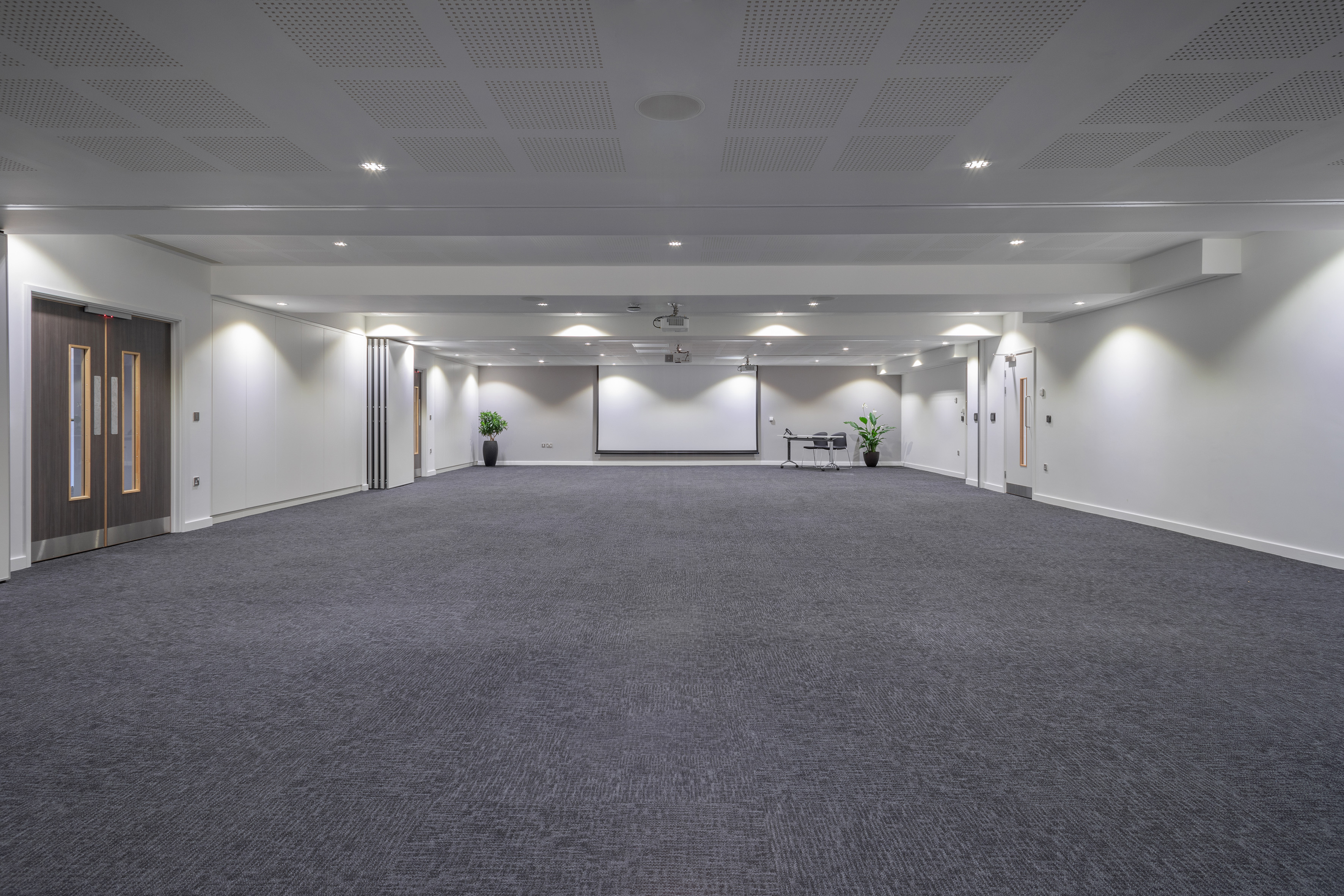 a large room with a screen and a table