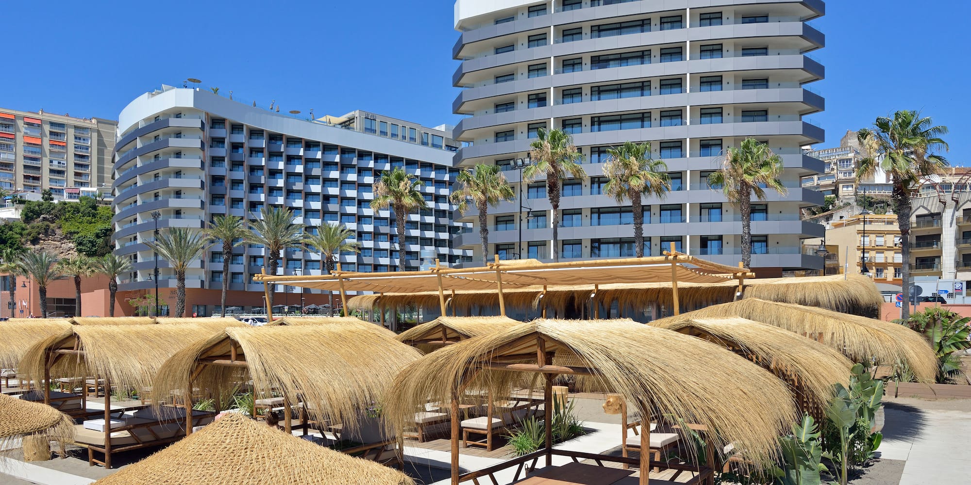 a group of straw umbrellas and a large building