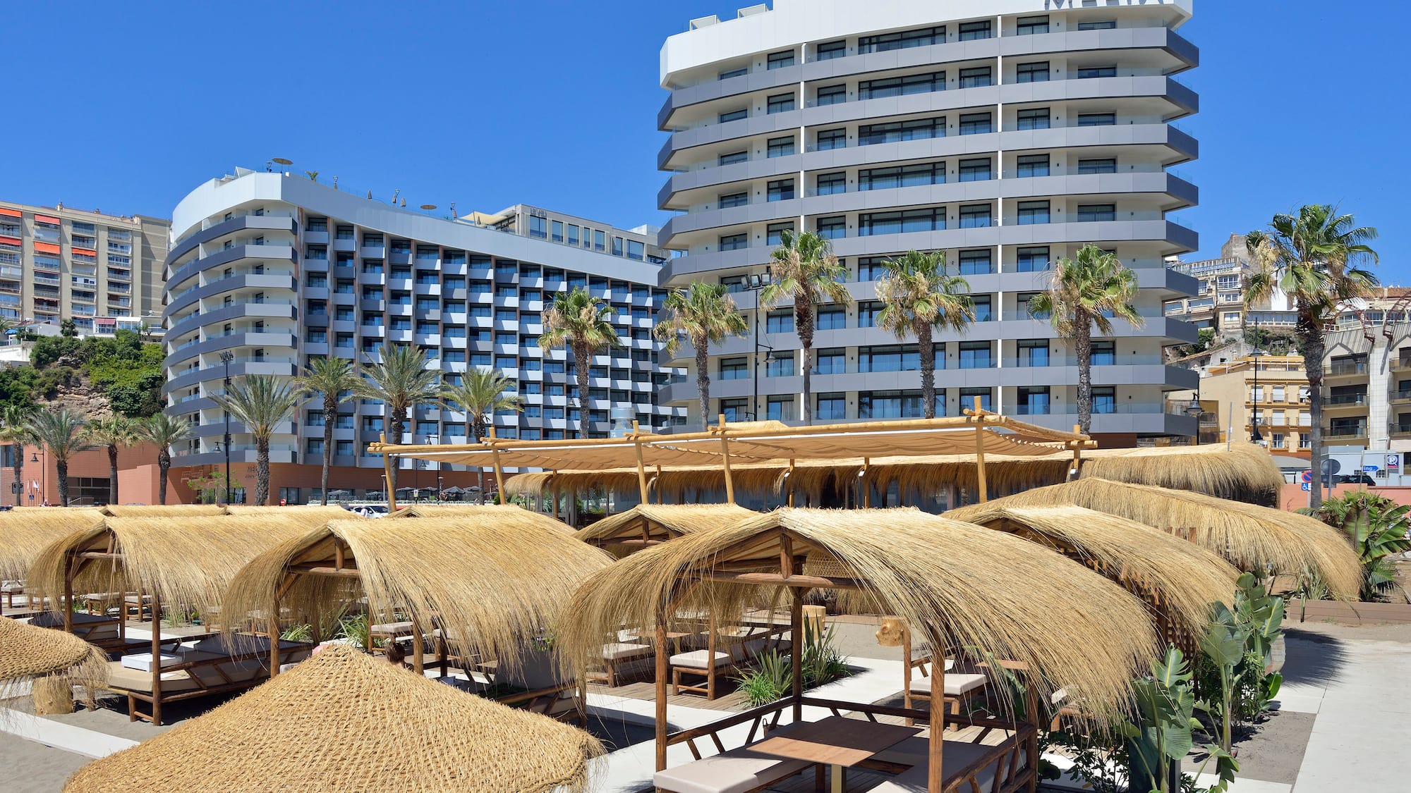 a group of straw umbrellas and a large building