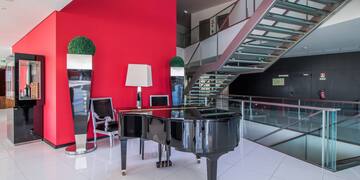 a piano in a room with a staircase