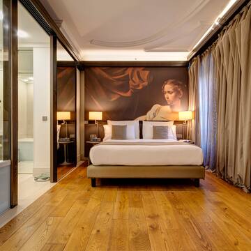 a bedroom with a large painting on the wall