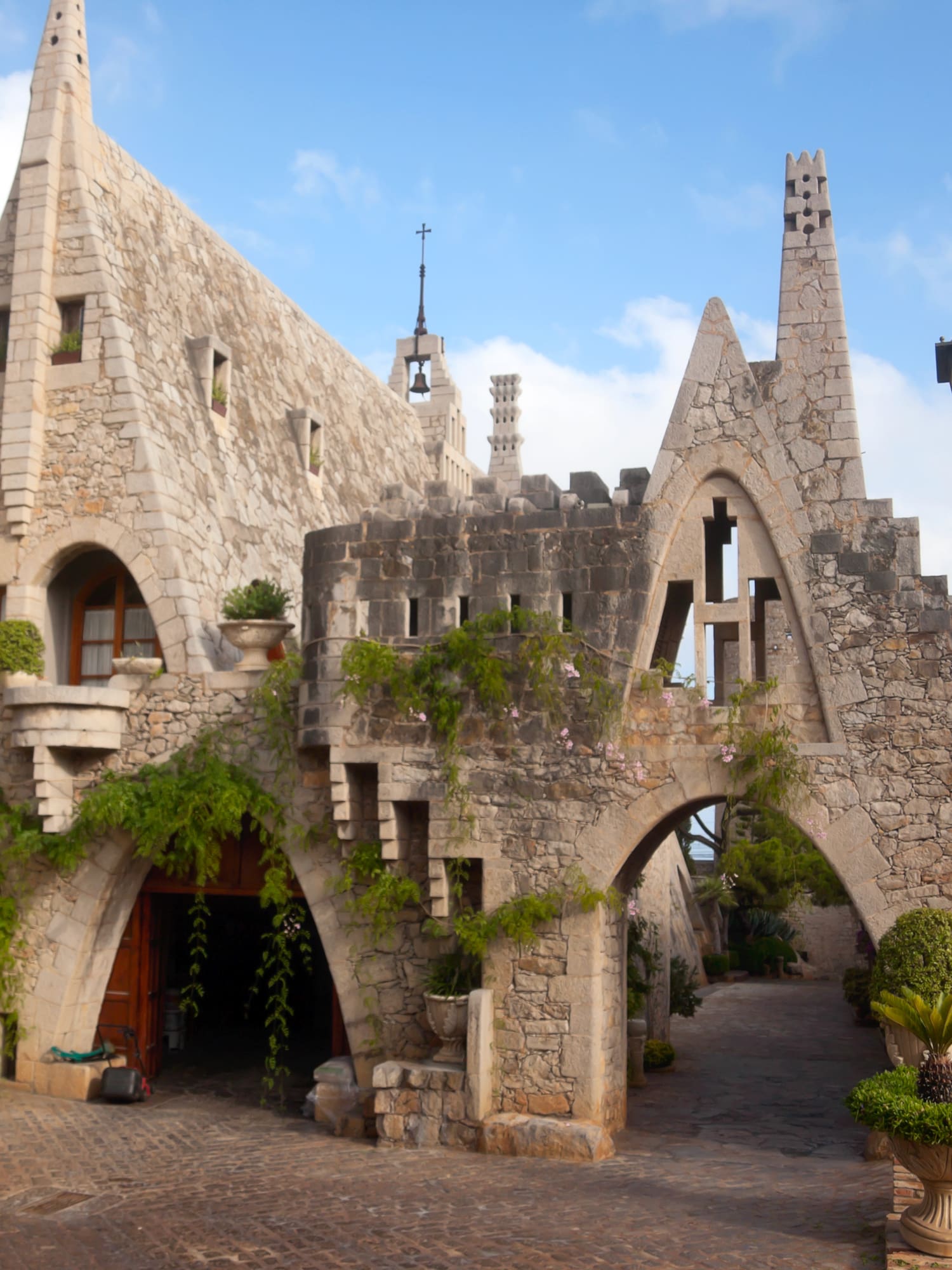 a stone building with a gate and plants