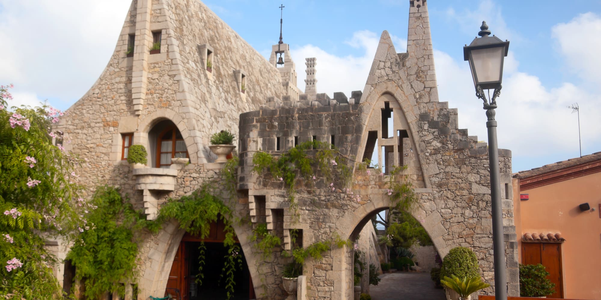 a stone building with a gate and plants