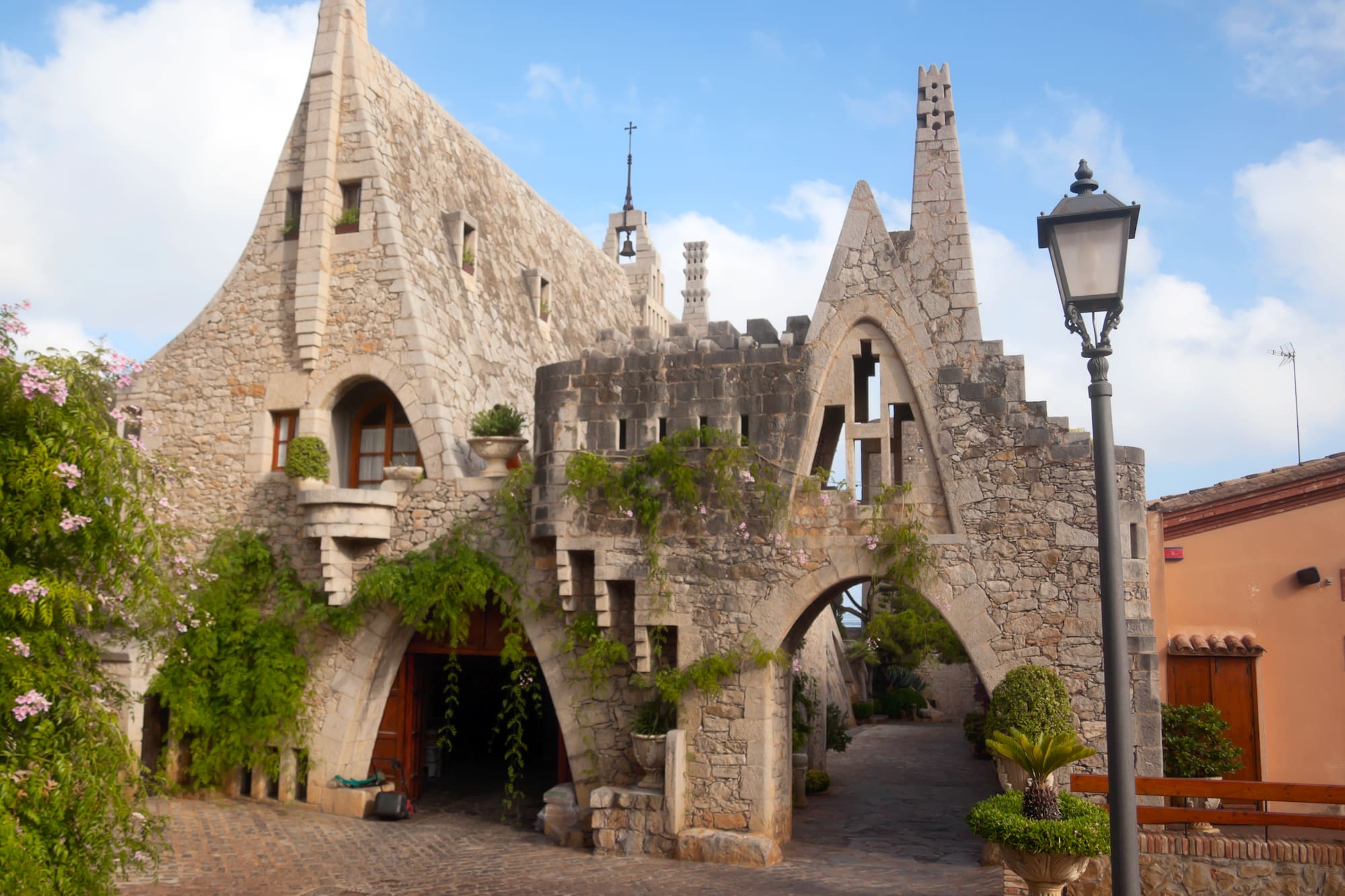a stone building with a gate and plants
