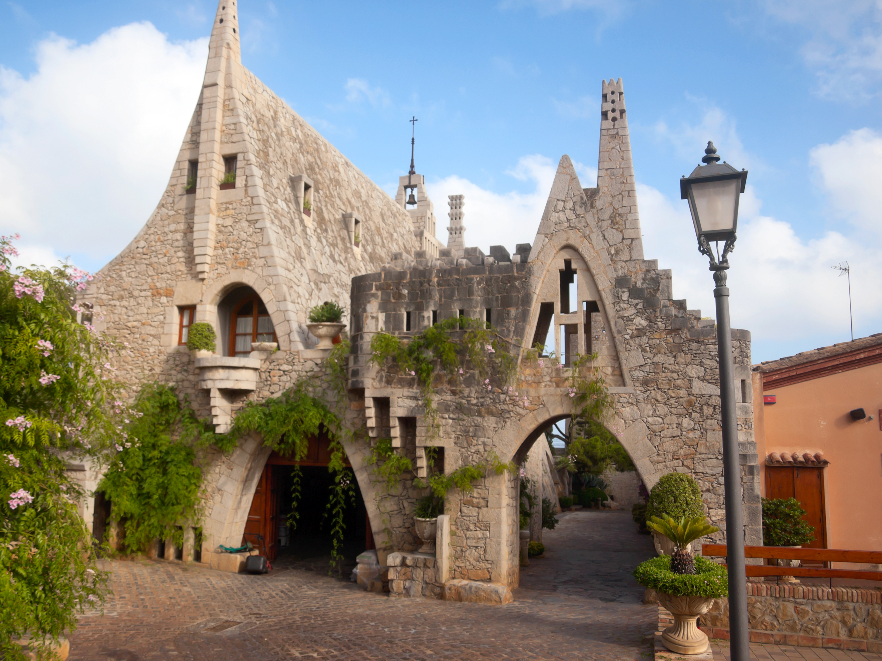a stone building with a gate and plants