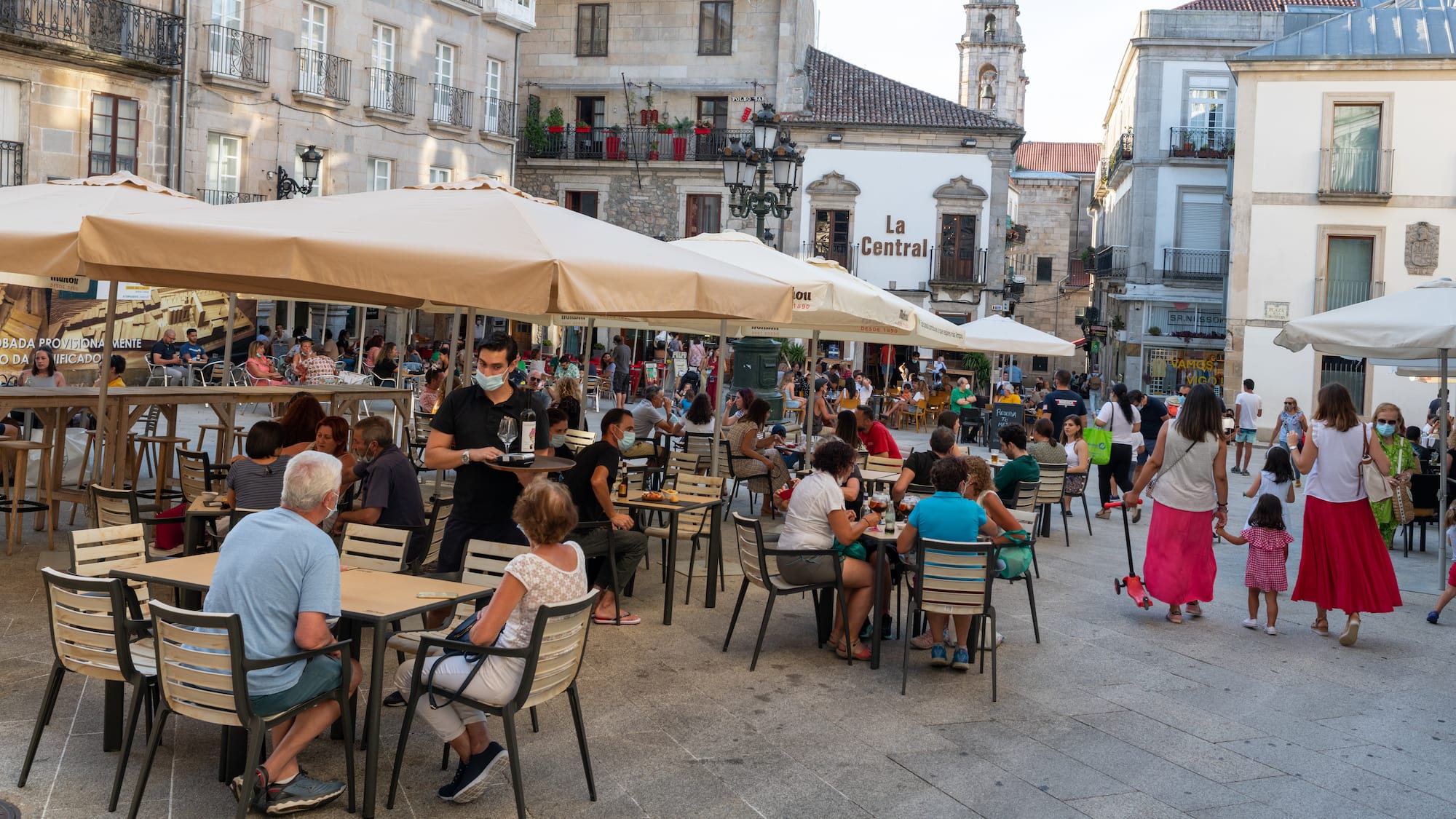 a group of people sitting at tables outside