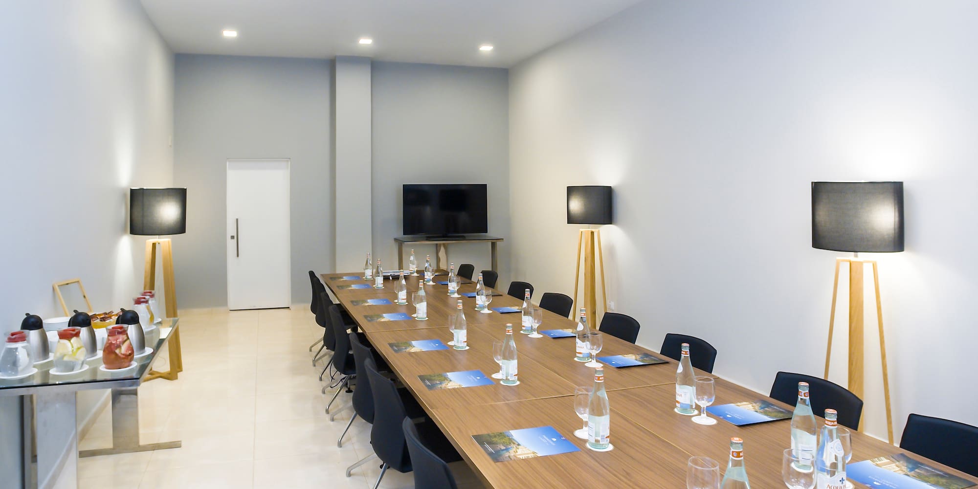 a long conference table with chairs and a television