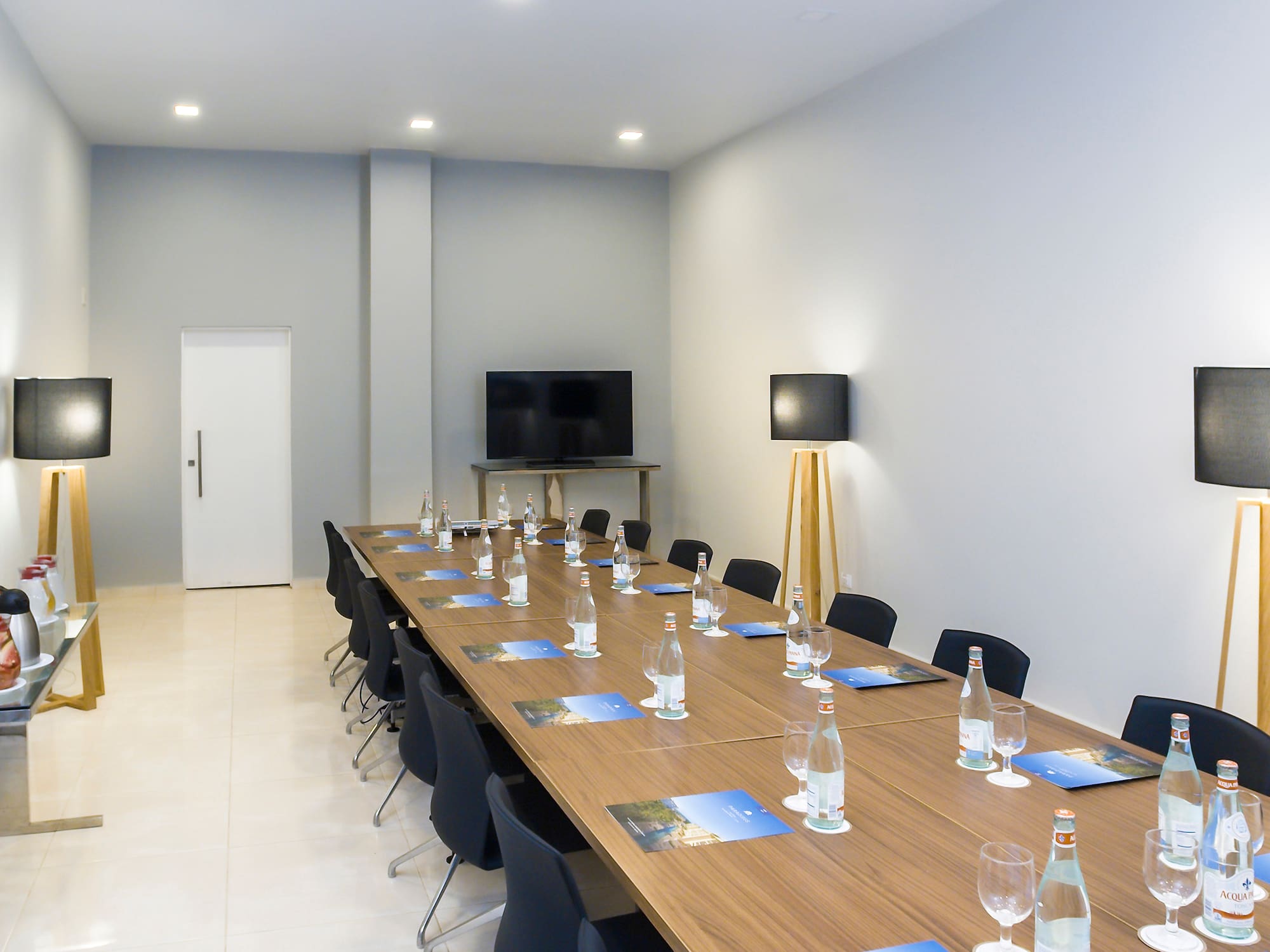 a long conference table with chairs and a television
