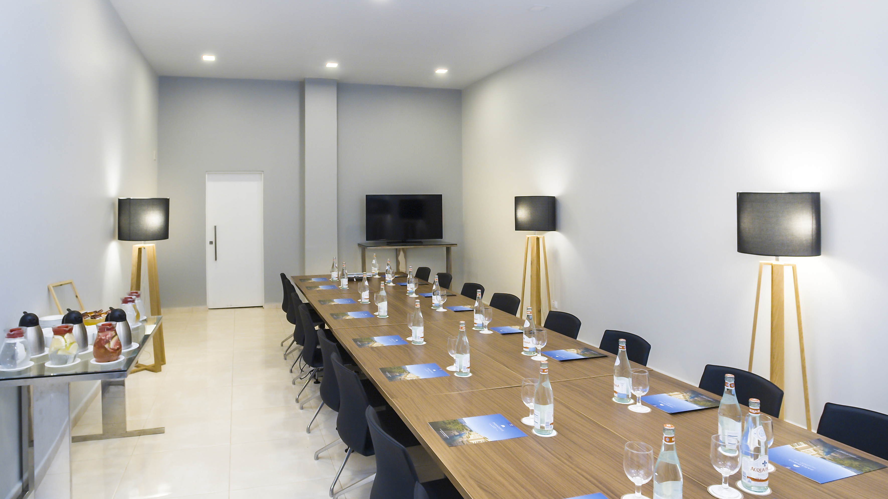 a long conference table with chairs and a television