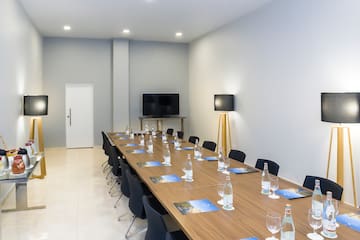 a long conference table with chairs and a television