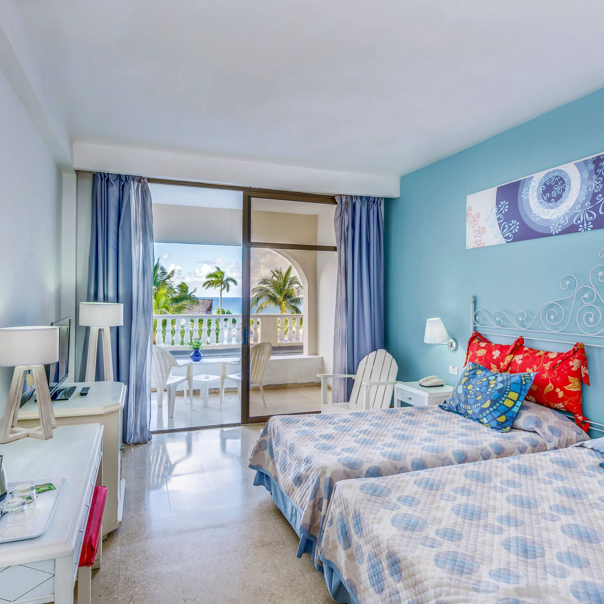 a bedroom with two beds and a glass door